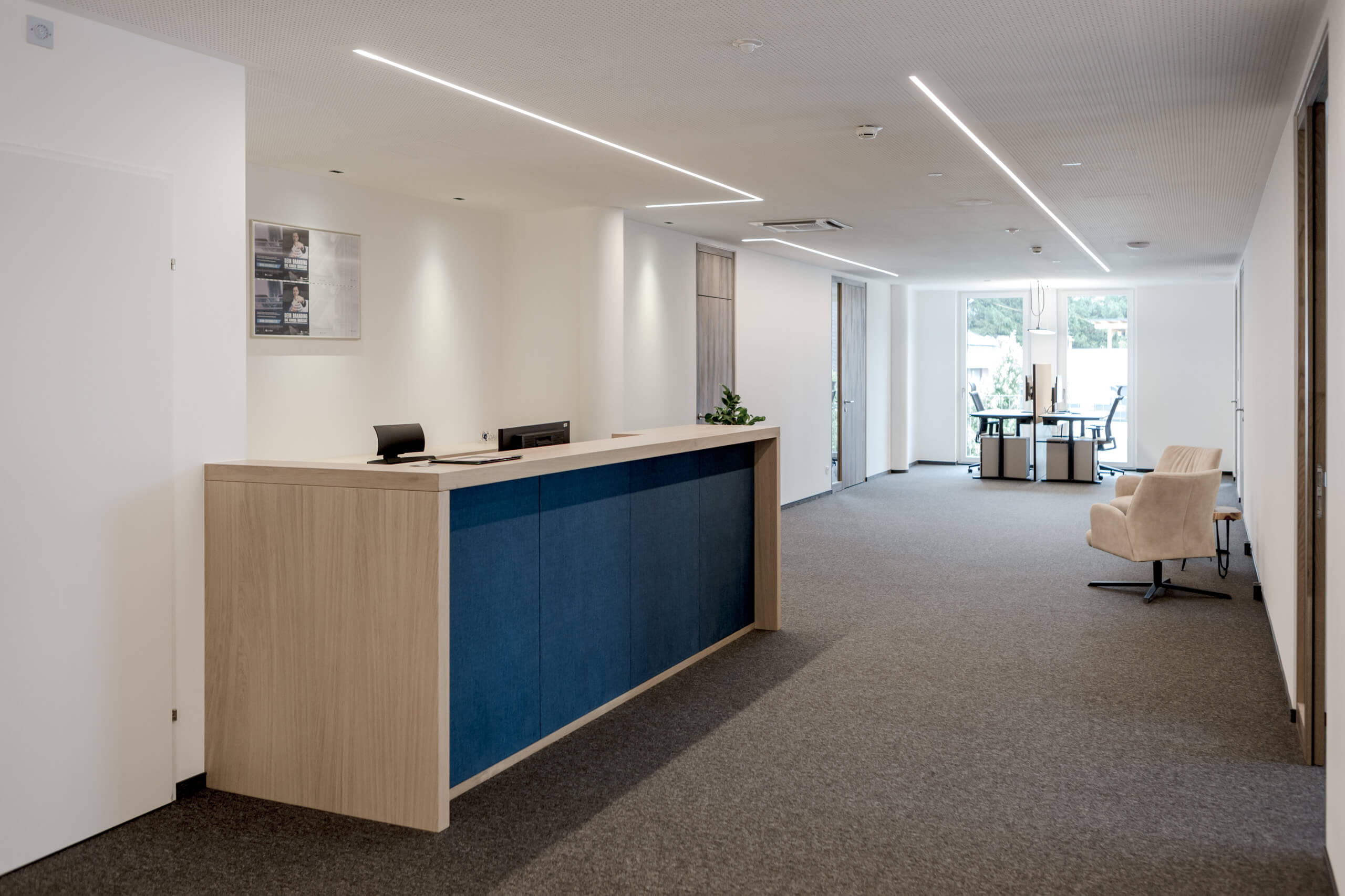 Moderne Bürorezeption mit blauem Empfangstresen und heller Beleuchtung