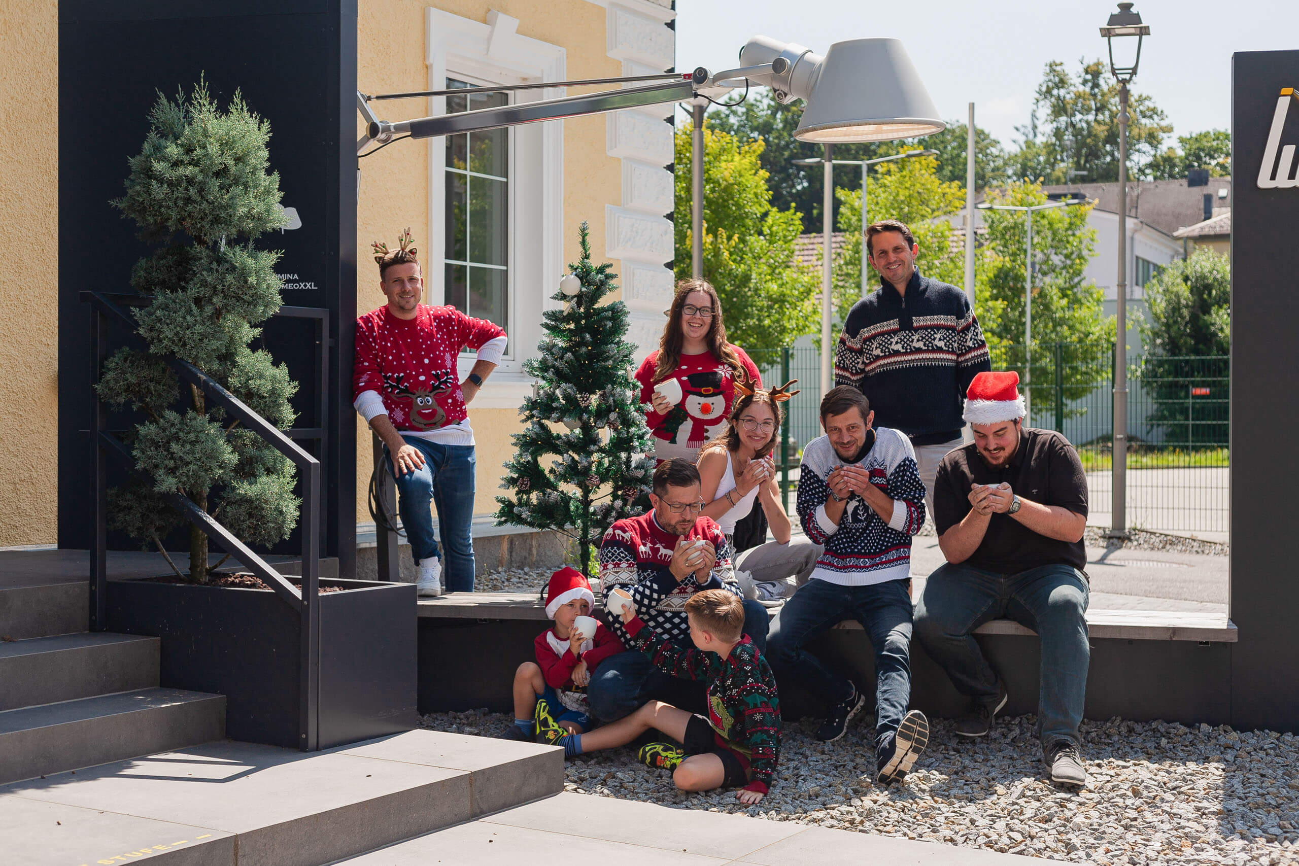 Weihnachtliche Gruppe in lustigen Pullis vor gelbem Gebäude