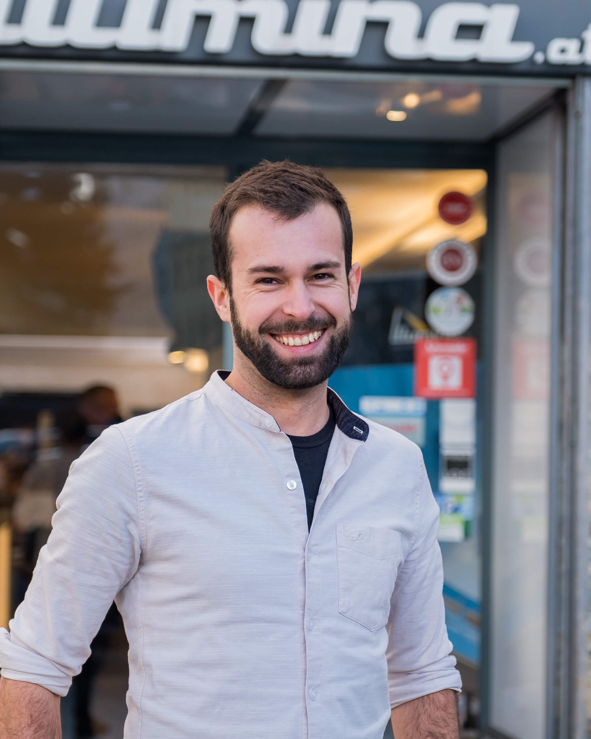 Raphael Huber lächelt vor dem Eingang vom Illumina Büro