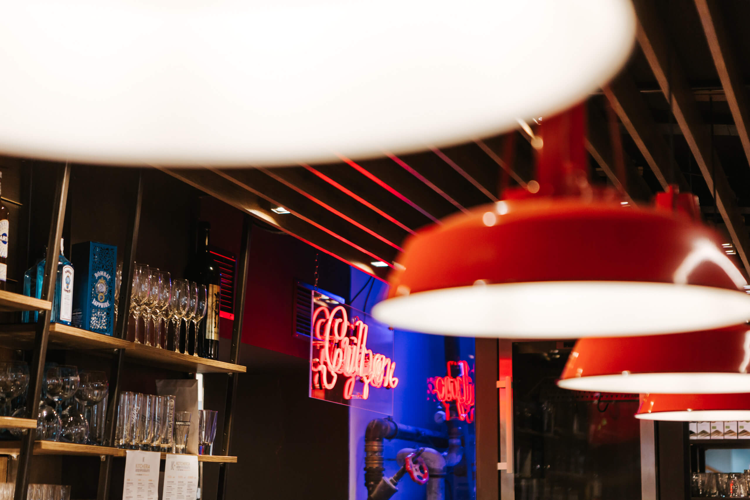 Leuchtenhandel in einem modernen Lokal mit roten Hängeleuchten und Neonlicht