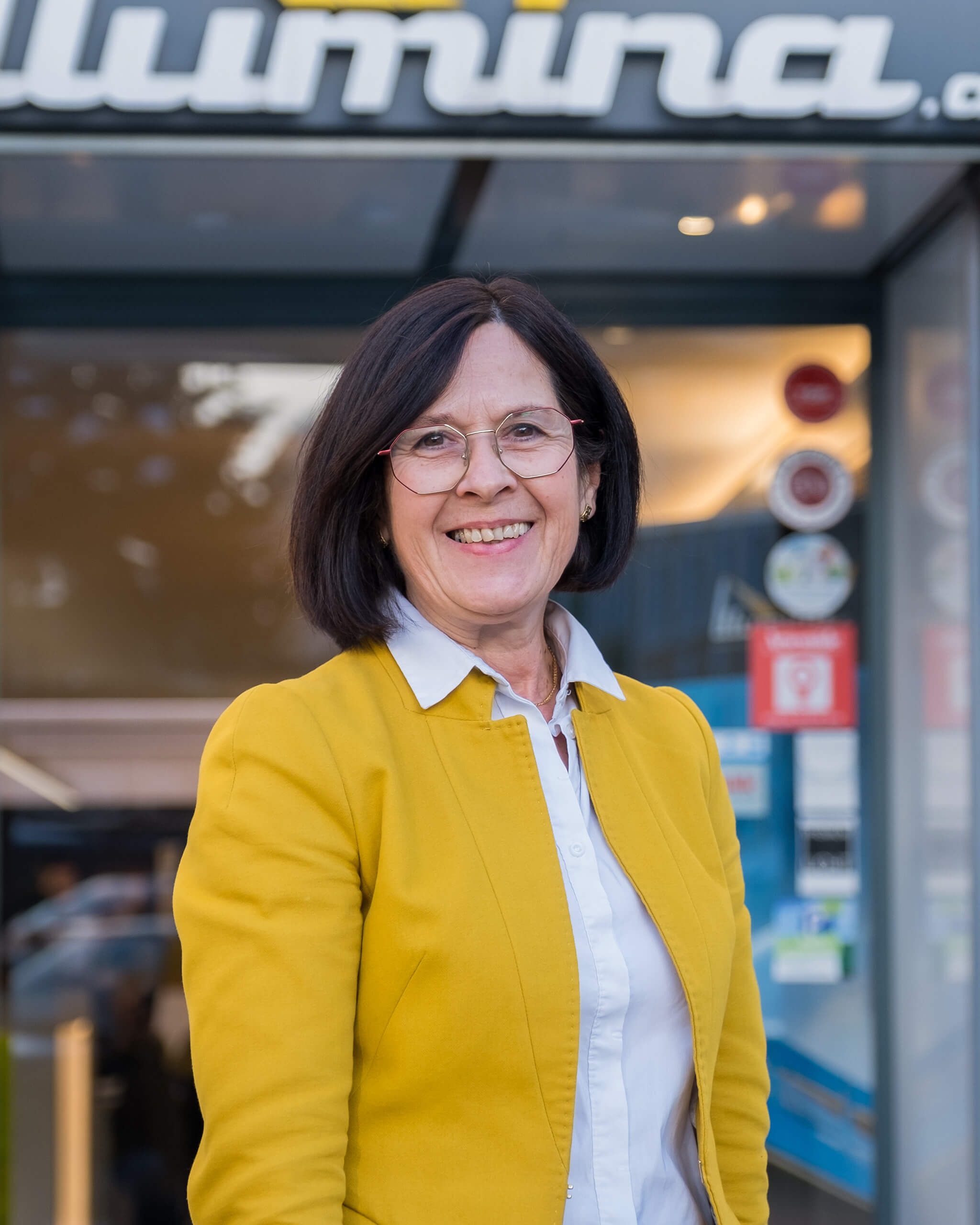 Theresa Huber vor Illumina-Gebäude mit gelber Jacke